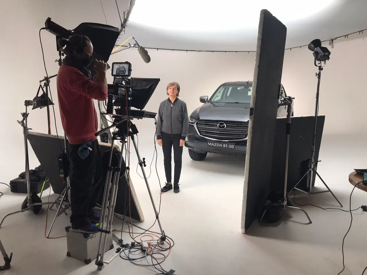 Camera rig and lighting set up around an SUV in studio